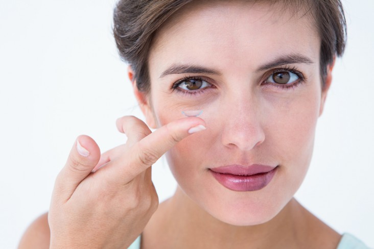 אישה שמה עדשת מגע